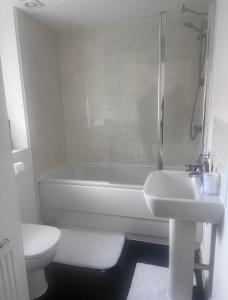 La salle de bains est pourvue d'une baignoire, d'un lavabo et de toilettes. dans l'établissement Solihull Guest House 1, à Olton