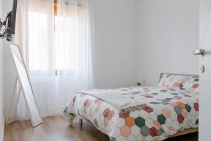 ein Schlafzimmer mit einem Bett mit einer Bettdecke und einem Fenster in der Unterkunft Massi 3 Monteverde in Rom