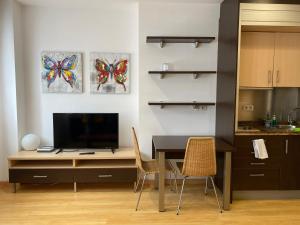 奧維多的住宿－Estudio Céntrico D1，厨房配有桌椅和电视。