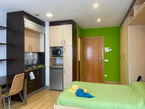 mały pokój z łóżkiem i kuchnią w obiekcie Estudio Céntrico D1 w mieście Oviedo