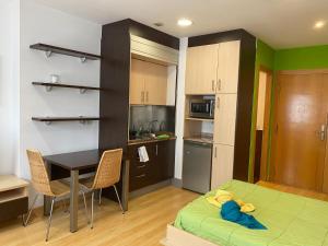 a room with a kitchen and a table and a bed at Estudio Céntrico D1 in Oviedo