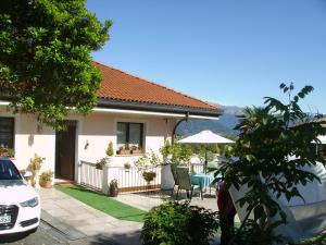 ein Haus mit einer Terrasse mit einem Tisch und einem Sonnenschirm in der Unterkunft B&B Madonna della Neve in Stresa