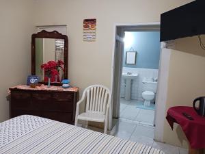 sypialnia z łóżkiem oraz łazienka z umywalką w obiekcie Tina's Guest House w mieście Ocho Rios
