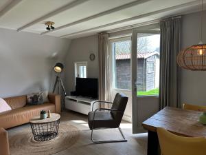 een woonkamer met een bank en een tafel bij Vakantiehuis Sofie Lauwersmeer met sauna in Anjum