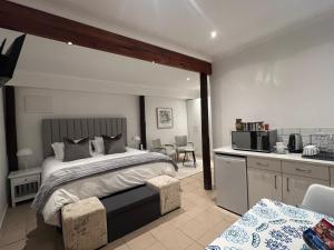 a bedroom with a large bed and a kitchen at Jefa Heights in Cape Town