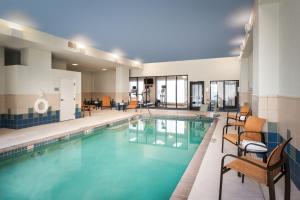 une grande piscine avec des chaises dans l'établissement Courtyard by Marriott St. Petersburg Downtown, à St Petersburg