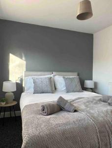 a bedroom with a large bed with blue walls at Spacious One-Bedroom in St. Helens in Burtonwood