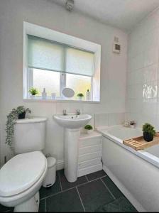 e bagno con servizi igienici, lavandino e vasca. di Spacious One-Bedroom in St. Helens a Burtonwood