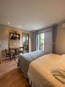1 dormitorio con 1 cama y comedor con mesa en Pousada Do Conde, en Campos do Jordão