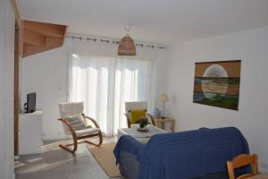 ein Wohnzimmer mit einem blauen Sofa und einem Stuhl in der Unterkunft La maison Des Cordelles in Saint-Denis-en-Val