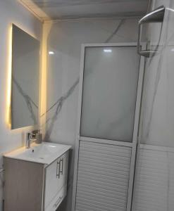 La salle de bains blanche est pourvue d'un lavabo et d'une douche. dans l'établissement HOTEL DE LOS COLORES, à Papagalleros