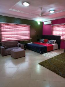 a bedroom with a large bed and a couch at jetfastventure in Accra