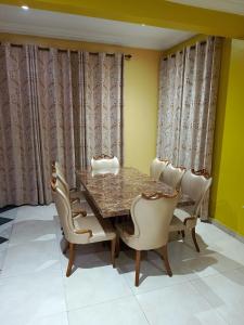 uma sala de jantar com mesa e cadeiras em jetfastventure em Acra
