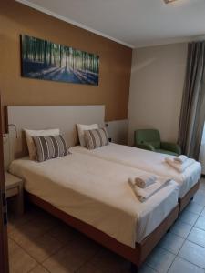 Appart-Hotel Gwendy في Bour: غرفة نوم بسرير كبير عليها منشفتين