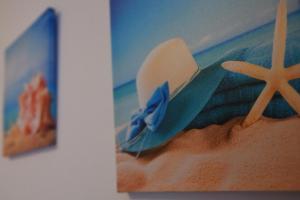 une photo d'une plage avec un chapeau et une peinture dans l'établissement Appartamento Lago Playa, à Desenzano del Garda