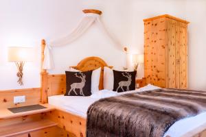 a bedroom with a bed with a wooden headboard at Chasa Castello relax & spa in Samnaun +151 photos