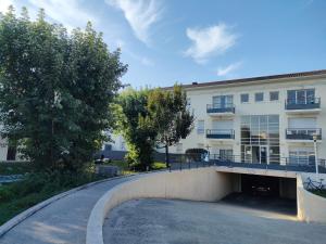 a building with a parking lot in front of it at Douceur et cocooning direct aéroport et Arkea Arena in Bègles