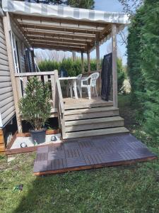 a wooden deck with chairs and a pergola at Camping les charmettes in Les Mathes +6 photos