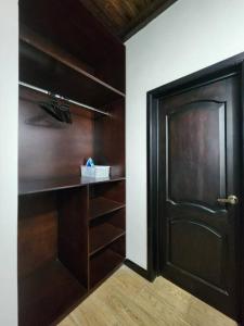 a closet with a black door and wooden shelves at Apartamento 1 Premiere de Occidente in Quetzaltenango