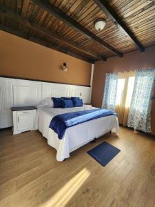 a bedroom with a large bed with blue pillows at Apartamento 1 Premiere de Occidente in Quetzaltenango