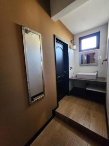 La salle de bains est pourvue d'un miroir, d'une porte et d'un lavabo. dans l'établissement Apartamento 1 Premiere de Occidente, à Quetzaltenango