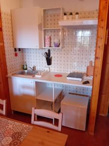 a small kitchen with white cabinets and a sink at Monolocale campo d'altura in Rieti