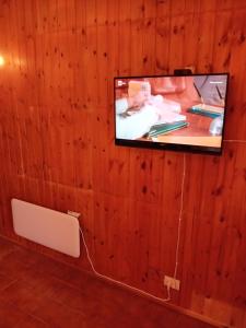 a tv hanging on a wooden wall with a bench at Monolocale campo d'altura in Rieti