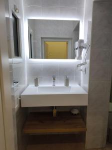 a bathroom with a white sink and a mirror at DIMORA FASANO in Bari