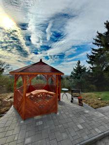 a wooden gazebo on a patio with a table at Sunset House Piestany Bungalow in Banka
