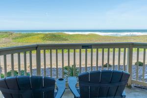 Duas cadeiras azuis sentadas numa varanda com vista para a praia em Ocean View Lodge em Fort Bragg