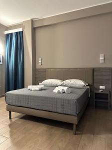 1 dormitorio con 1 cama con 2 toallas en Sunset Guest House en Reggio Calabria