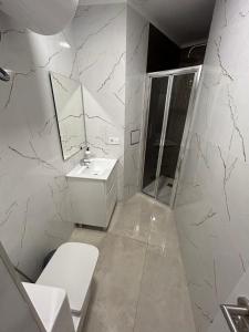 a bathroom with a sink and a toilet and a mirror at Elegance Apartment in Alicante
