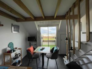 een woonkamer met een tafel en stoelen bij APPARTEMENT VUE PORT CROUESTY in Arzon