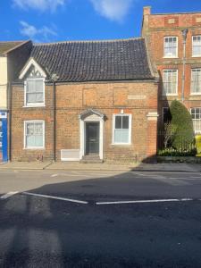 a brick house with a door on a street at Lovely Getaway Apartment in Wisbech in Wisbech