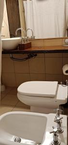 a bathroom with a white toilet and a sink at Portal del Sol in San Ignacio