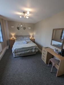 a bedroom with a bed and a desk and a mirror at Prestleigh inn in Shepton Mallet