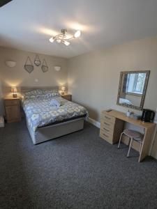 - une chambre avec un lit, un bureau et un miroir dans l'établissement Prestleigh inn, à Shepton Mallet