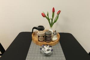 a table with a tray with jars and a vase of flowers at Warmzy Home - Modern 2 Rooms Apartment With Free Parking in Vilnius +16 photos