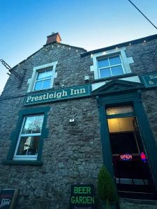 un edificio de ladrillo con un cartel para una taberna al aire libre en Prestleigh inn, en Shepton Mallet