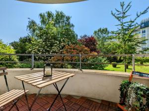 una mesa en un balcón con vistas a los árboles en Studio Cosy au pied de la gare de Cergy le Haut - 35 min de Paris en Cergy