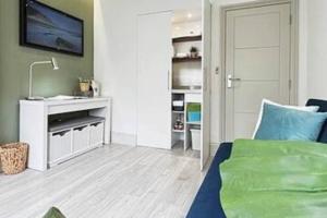 Un dormitorio con una cama y un escritorio con televisión. en Apt 06 Stylish Studio steps from Beach, Cafe's & Bar's, en Brighton & Hove