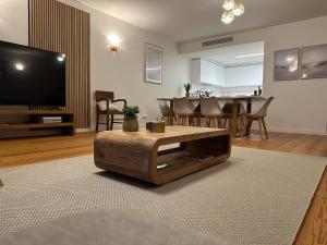 a living room with a tv and a coffee table at BaySun Apartment & SPA - Bayline in Armação de Pêra