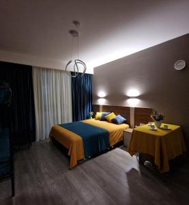 a hotel room with a bed and two tables at Crystal Wood Apartment 213 in Bakuriani