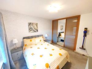 una camera da letto con un letto bianco a pois gialli di The Relish - ground floor flat in Largs a Largs