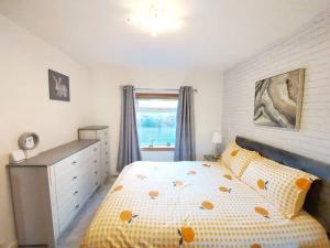 a bedroom with a bed and a window at The Relish - ground floor flat in Largs in Largs