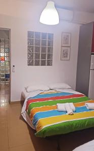 een groot bed in een kamer met een kleurrijke deken bij Riverside Triana in Sevilla