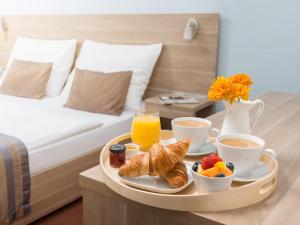 a tray of breakfast food on a table in a hotel room at SCN Pet-friendly Hotel โรงแรมรับสัตว์เลี้ยง in Ban Chang
