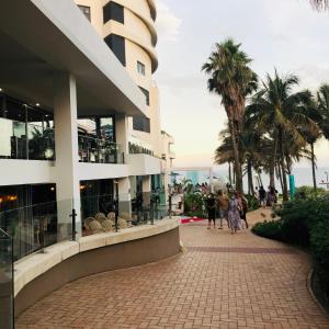 people walking down a sidewalk next to a building at Iconic Pearls of Umhlanga in Durban