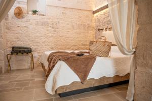 a bedroom with a bed in a stone wall at B&B TRULLI MIRIVA' in Alberobello