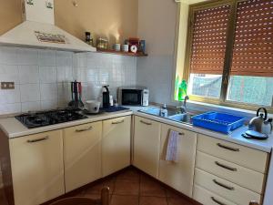 una cucina con lavandino e piano cottura forno superiore di Antonio's villa al mare con vista sull'Etna Vaccarizzo Catania a Catania